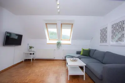a living room with a couch and a tv at Duplex Apartment Panj Kranjska Gora in Kranjska Gora