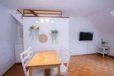 a dining room with a wooden table and chairs at Duplex Apartment Panj Kranjska Gora in Kranjska Gora