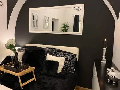 a living room with a couch and a mirror at Apartment Capital in Maribor