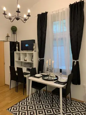 a dining room with a white table and black chairs at Apartment Capital in Maribor