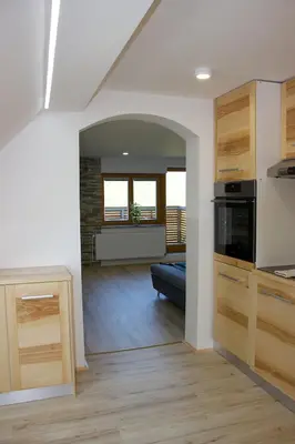 a kitchen and living room with a blue couch in a room at Malina in Vransko