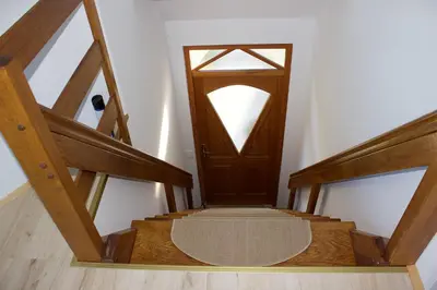 a hallway with a wooden door and a stair case at Malina in Vransko