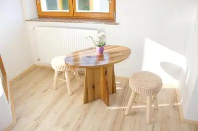 a wooden table and two stools in a room at Malina in Vransko