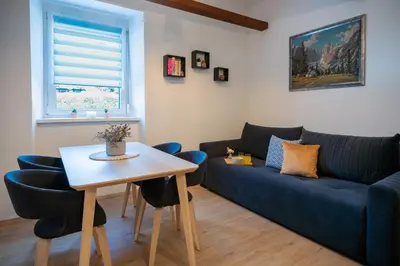 a living room with a blue couch and a table at BonAire apartment in Kranjska Gora