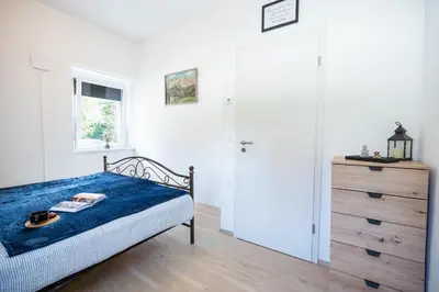 a bedroom with a bed and a dresser and a window at BonAire apartment in Kranjska Gora
