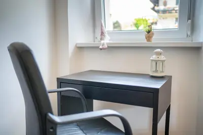 a black desk with a chair and a window at BonAire apartment in Kranjska Gora