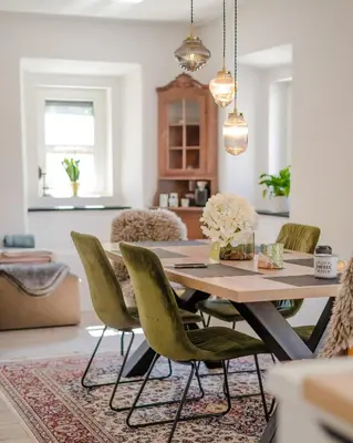 a dining room with a table and green chairs at AVA HOUSE in Kranjska Gora