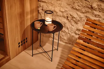 a small table with a candle and two cups on it at AVA HOUSE in Kranjska Gora