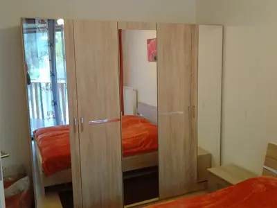 a bedroom with wooden cupboards and a bed at Izzi apartma in Kranjska Gora