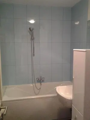 a bathroom with a shower and a tub and a sink at Izzi apartma in Kranjska Gora