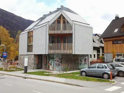 a house with a balcony on top of it at Izzi apartma in Kranjska Gora