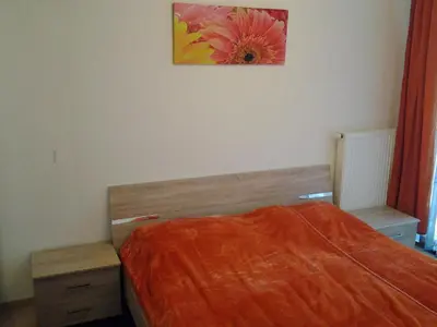 a bedroom with a bed with a flower painting on the wall at Izzi apartma in Kranjska Gora