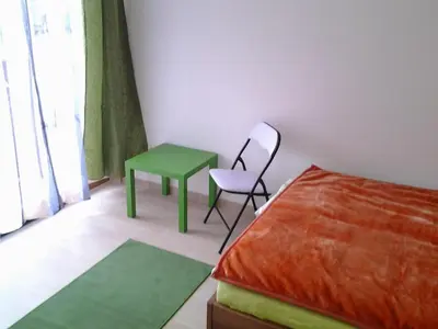 a bedroom with a bed and a chair and a table at Izzi apartma in Kranjska Gora