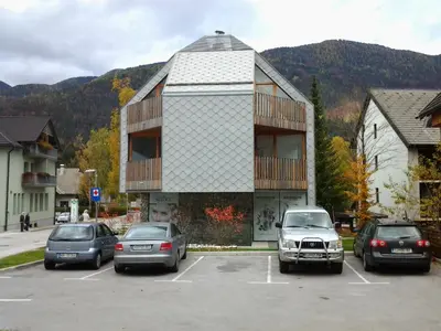 a parking lot with cars parked in front of a building at Izzi apartma in Kranjska Gora