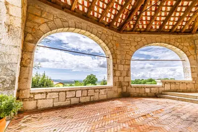 an empty room with two windows and a stone wall at Vila Brinovka in Kostanjevica na Krasu