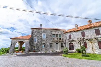 a large stone building with an archway in a yard at Vila Brinovka in Kostanjevica na Krasu