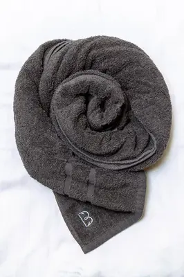 a gray towel laying on top of a bed at Vila Brinovka in Kostanjevica na Krasu