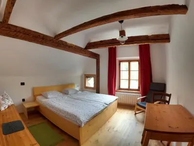 a bedroom with a large bed and a table at Juvanova hiša (all house) in Luče