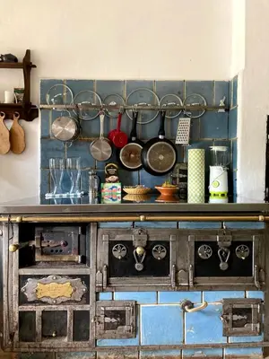 a kitchen with an old stove with pots and pans at Juvanova hiša (all house) in Luče