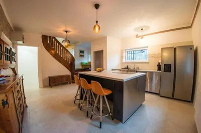 a kitchen with a large island with bar stools at Vila Park Ravne in Ravne na Koroškem