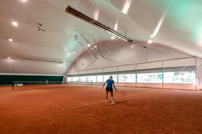 a woman standing on a tennis court with a racket at Vila Park Ravne in Ravne na Koroškem