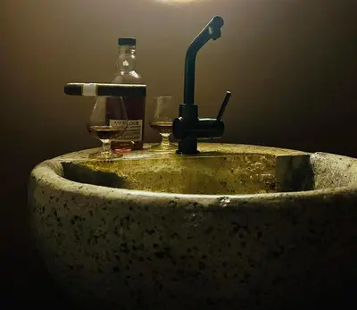 a dirty sink with a bottle and a glass at Vila Park Ravne in Ravne na Koroškem