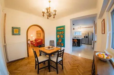 a dining room and living room with a table and chairs at Vila Park Ravne in Ravne na Koroškem