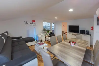 a living room with a couch and a dining table at Villa DonLeone in Ponikva