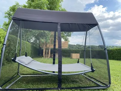 a swing bed with a canopy in a yard at Villa DonLeone in Ponikva