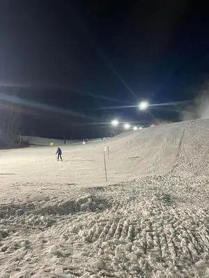 a person skiing down a snow covered slope at night at Apartma Lana in Mojstrana