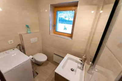 a bathroom with a sink and a toilet and a window at Apartma Lana in Mojstrana