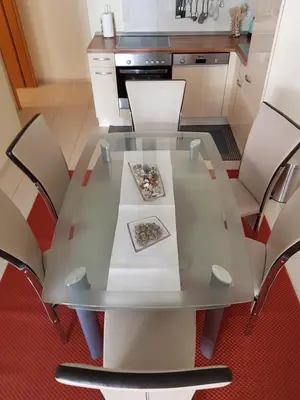 a glass table in a kitchen with chairs at Apartment Ranc in Kranjska Gora