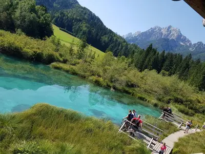 a group of people standing on a bridge over a river at Apartment Ranc in Kranjska Gora
