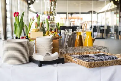a table with plates and dishes on a table at Panonska Vas Apartments in Moravske Toplice