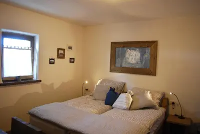a bedroom with a bed with two pillows on it at Panonska Vas Apartments in Moravske Toplice