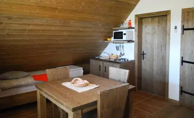 a small kitchen with a table and a bed at Panonska Vas Apartments in Moravske Toplice