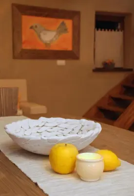 a white bowl sitting on a table with two lemons at Panonska Vas Apartments in Moravske Toplice
