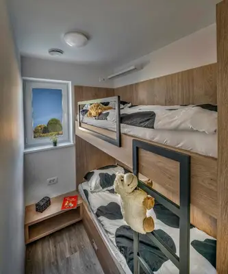 a bedroom with two bunk beds and a teddy bear on a shelf at Vila Vernig in Bled
