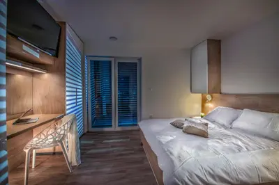 a bedroom with a bed and a desk with a chair at Vila Vernig in Bled