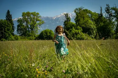 a little girl running through a field of tall grass at Vila Vernig in Bled