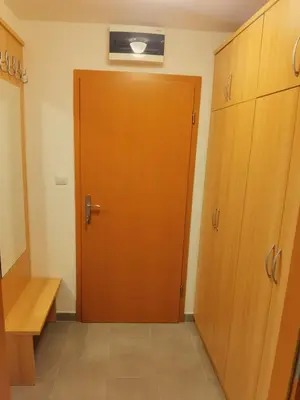 a wooden door in a room with a bench at Apartma Happy in Kranjska Gora