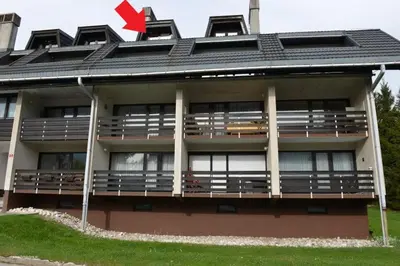 a building with a red arrow on top of it at Apartma Happy in Kranjska Gora