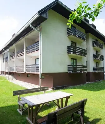 a building with a picnic table and a bench in front of it at Apartma Happy in Kranjska Gora