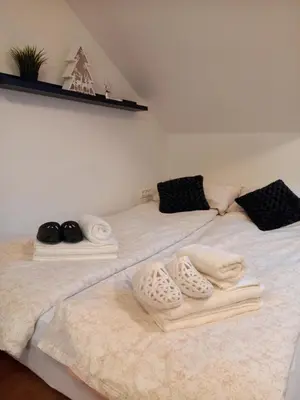 two beds with white towels on them in a room at Apartma Happy in Kranjska Gora