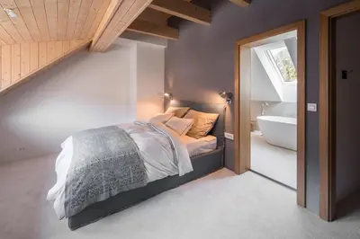 a bedroom with a bed and a bathroom with a tub at Our Second Home in Kranjska Gora in Kranjska Gora