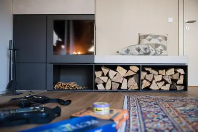 a living room with a fireplace with fire wood at Our Second Home in Kranjska Gora in Kranjska Gora
