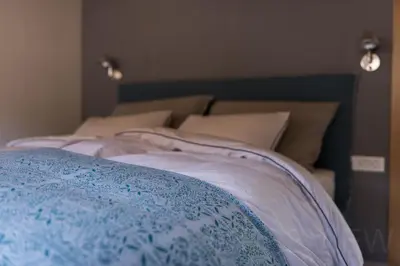a bed with a blue and white blanket on it at Our Second Home in Kranjska Gora in Kranjska Gora