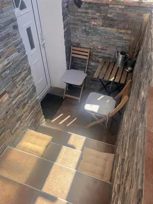 a patio with a door and a chair and a table at Lovely basement rental in Bled