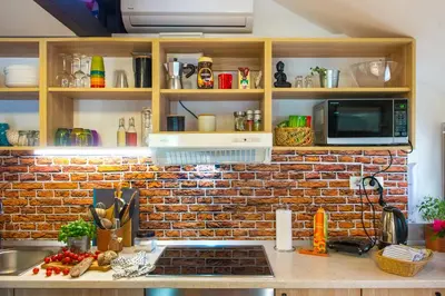 a kitchen with a brick wall and a counter top at Boho House 3 camp Terme Catez with promotional tickets prices in Čatež ob Savi