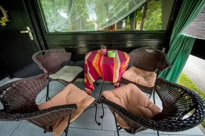 a table and chairs on a screened in porch at Boho House 3 camp Terme Catez with promotional tickets prices in Čatež ob Savi